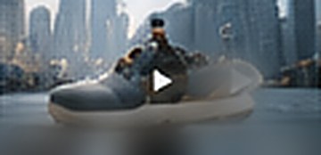 Sneaker floating above water against a city skyline