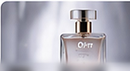 Perfume bottle lit on a soft grey backdrop